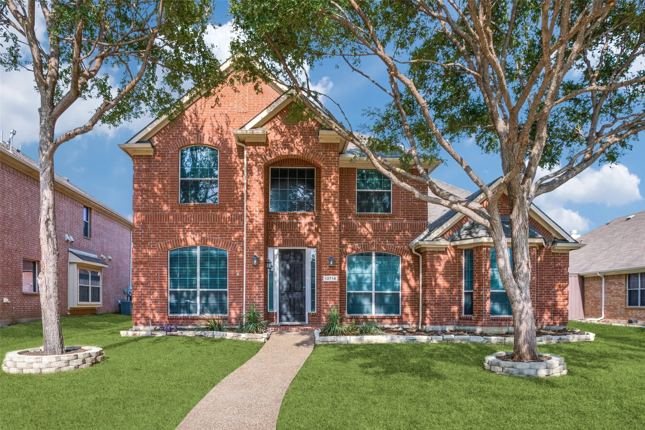 Traditional home with a front yard and brick siding