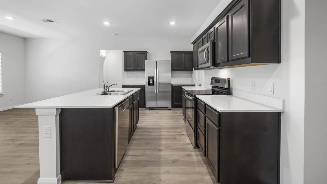 Modern kitchen featuring dark wood cabinetry, stainless steel appliances, and light-colored countertops