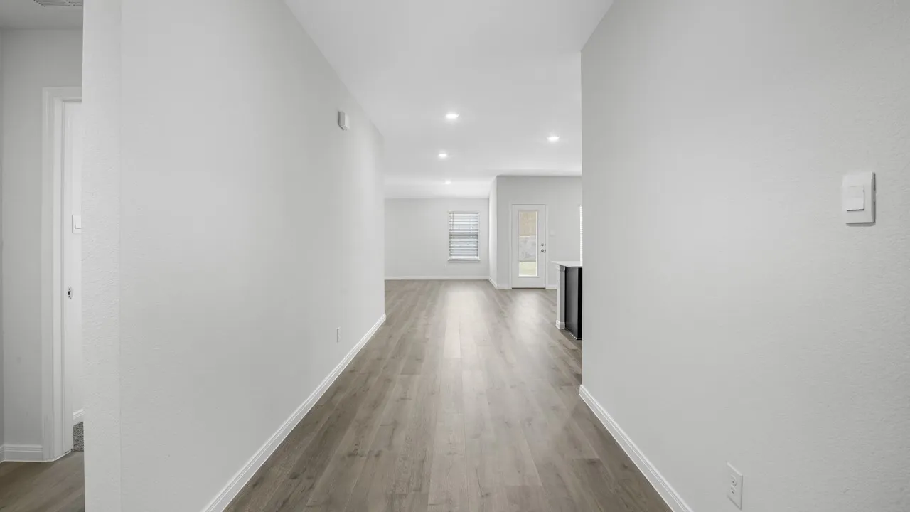 Bright interior hallway featuring wood-finish flooring and recessed lighting