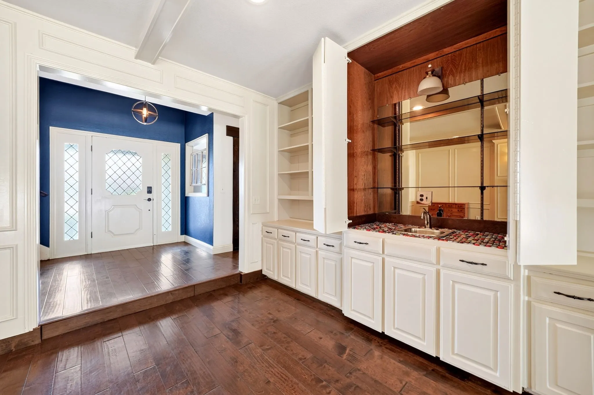 Living room with built-in cabinets with a wet bar and sink