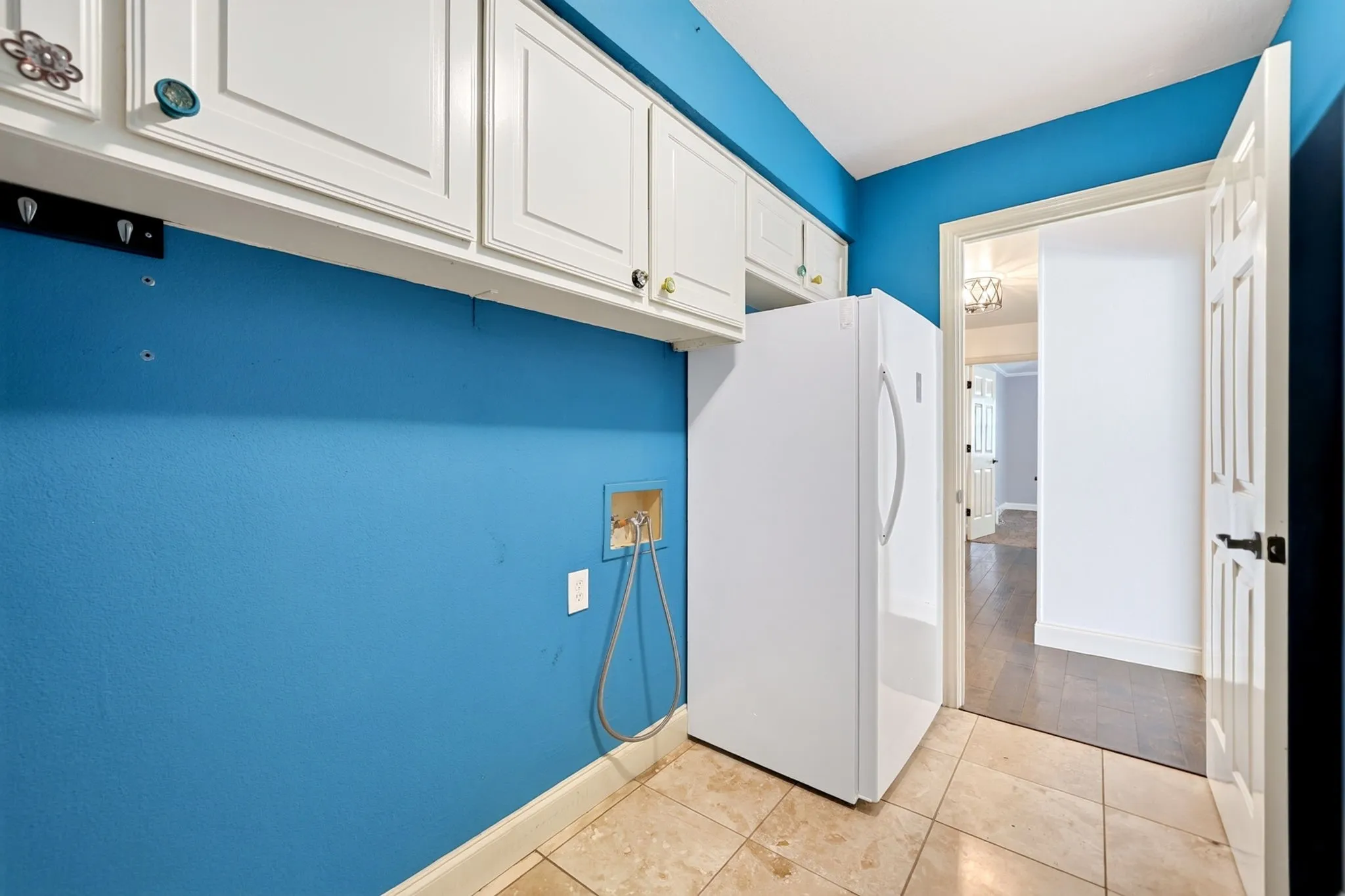 Laundry room with space for an extra refrigerator and leads to the garage.