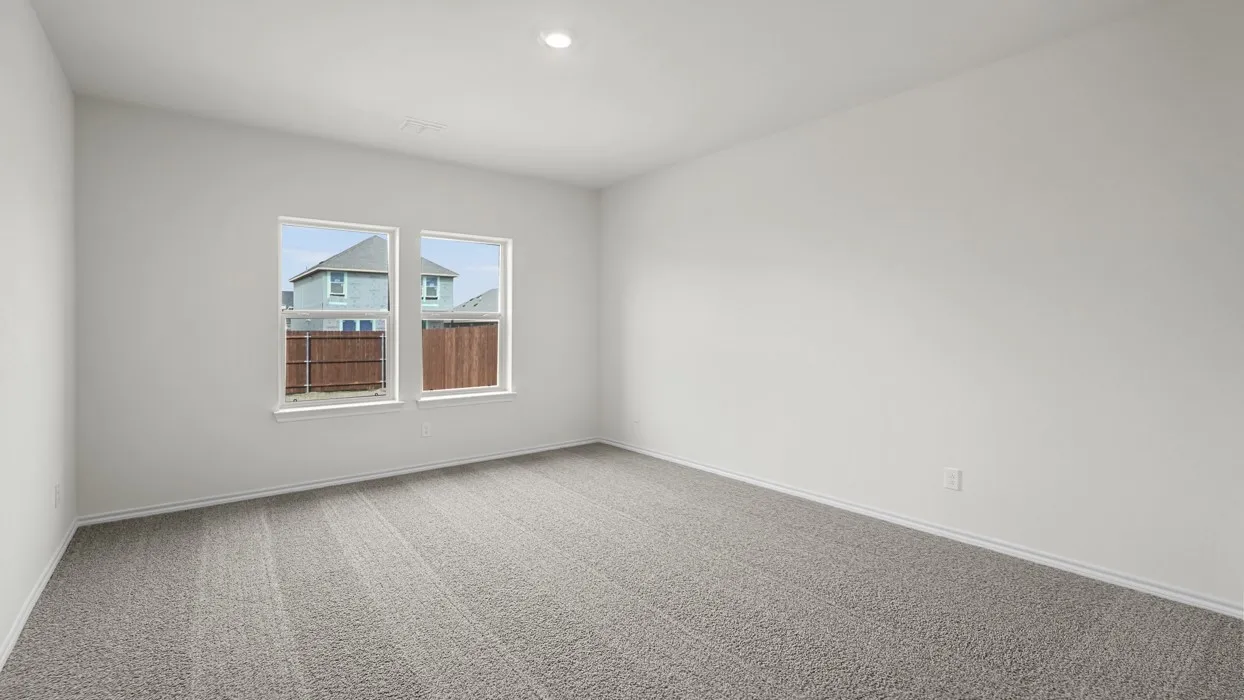 Spacious interior room featuring light gray carpeting, crisp white walls, and two large windows