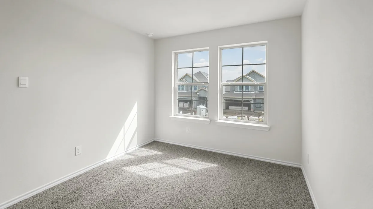 Room featuring two windows with grid detailing, neutral-toned wall paint, gray carpeting, and white baseboards