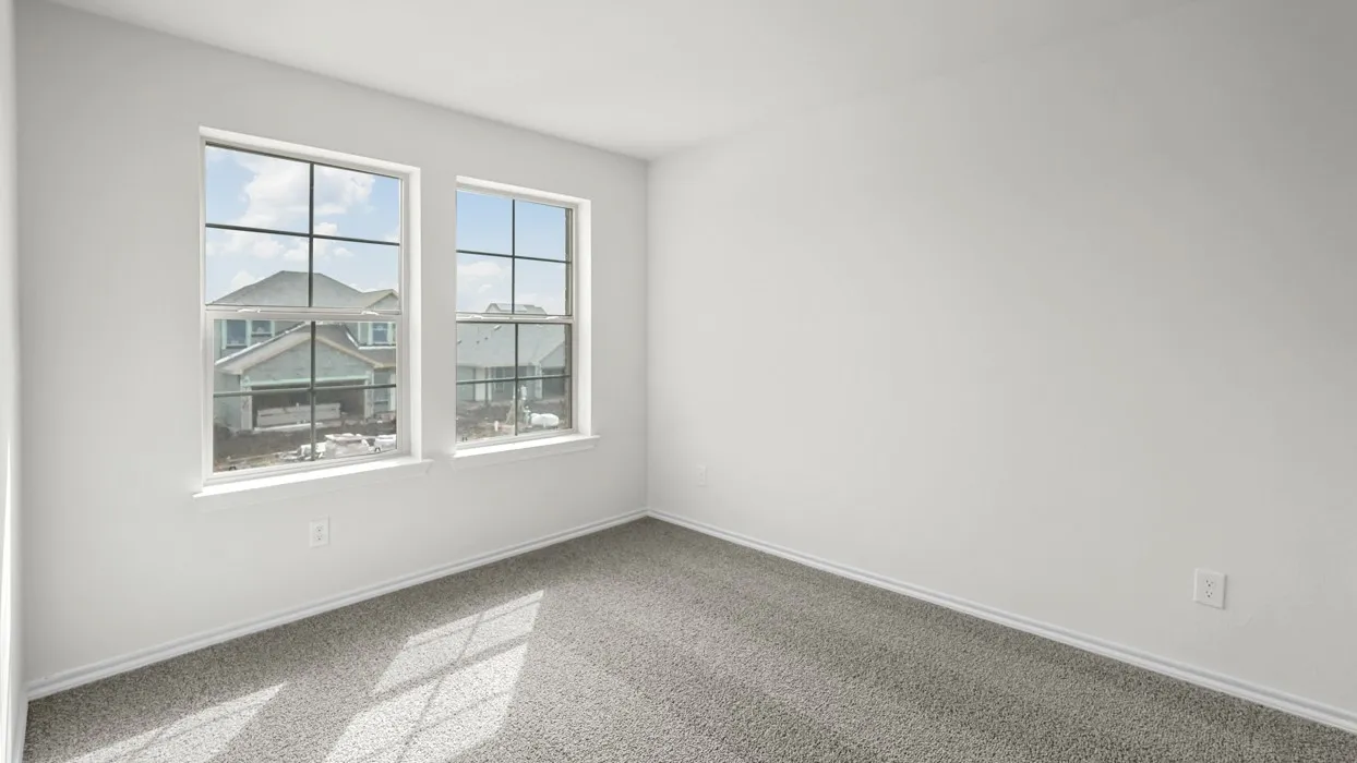 Bright interior space featuring two large windows, white walls, and gray carpet