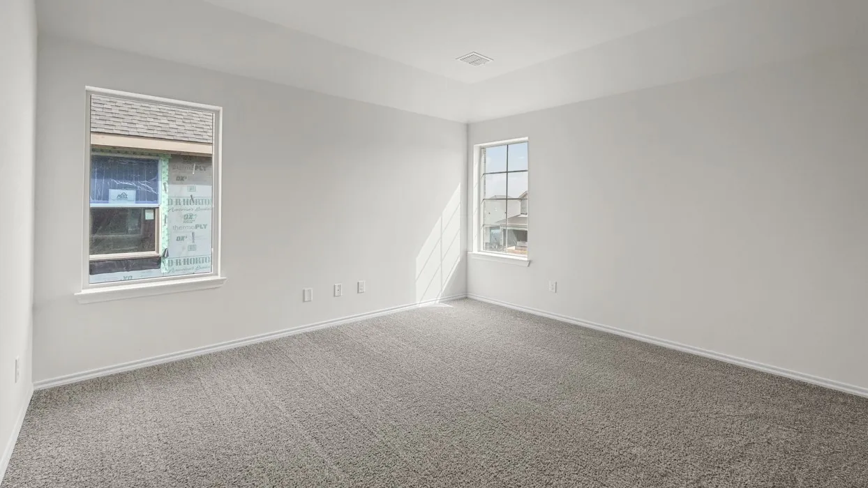 Spacious room featuring neutral grey carpeting, crisp white walls, and a recessed ceiling detail