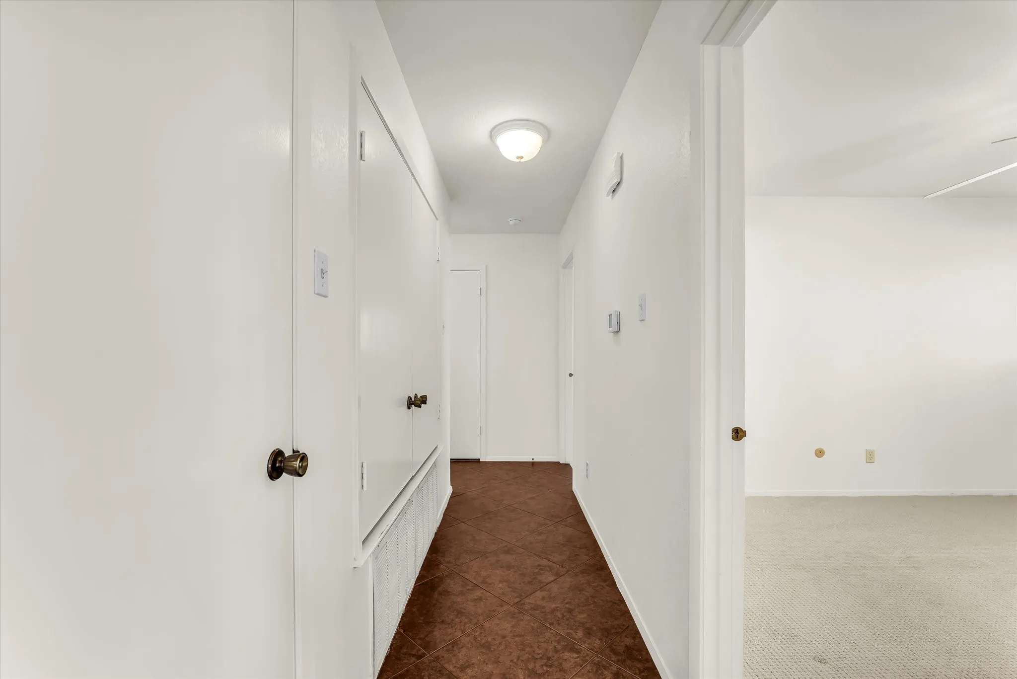 Hallway with tiled flooring and recessed lighting