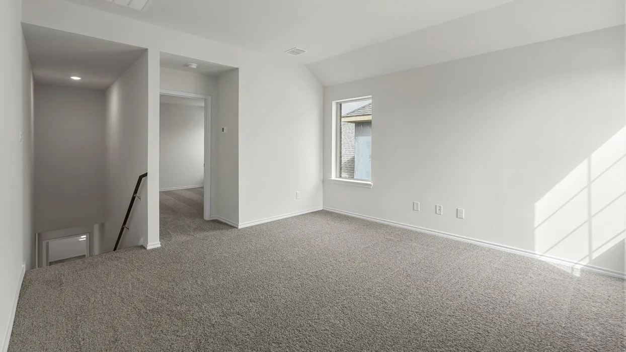 Carpeted open area with white walls and a single window