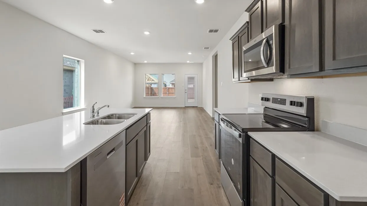 Kitchen featuring a large island with a double basin sink and stainless steel dishwasher