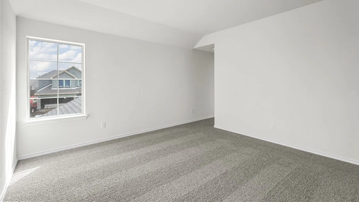 Spacious room featuring neutral carpeting, white wall finishes, and an expansive window with grid panes