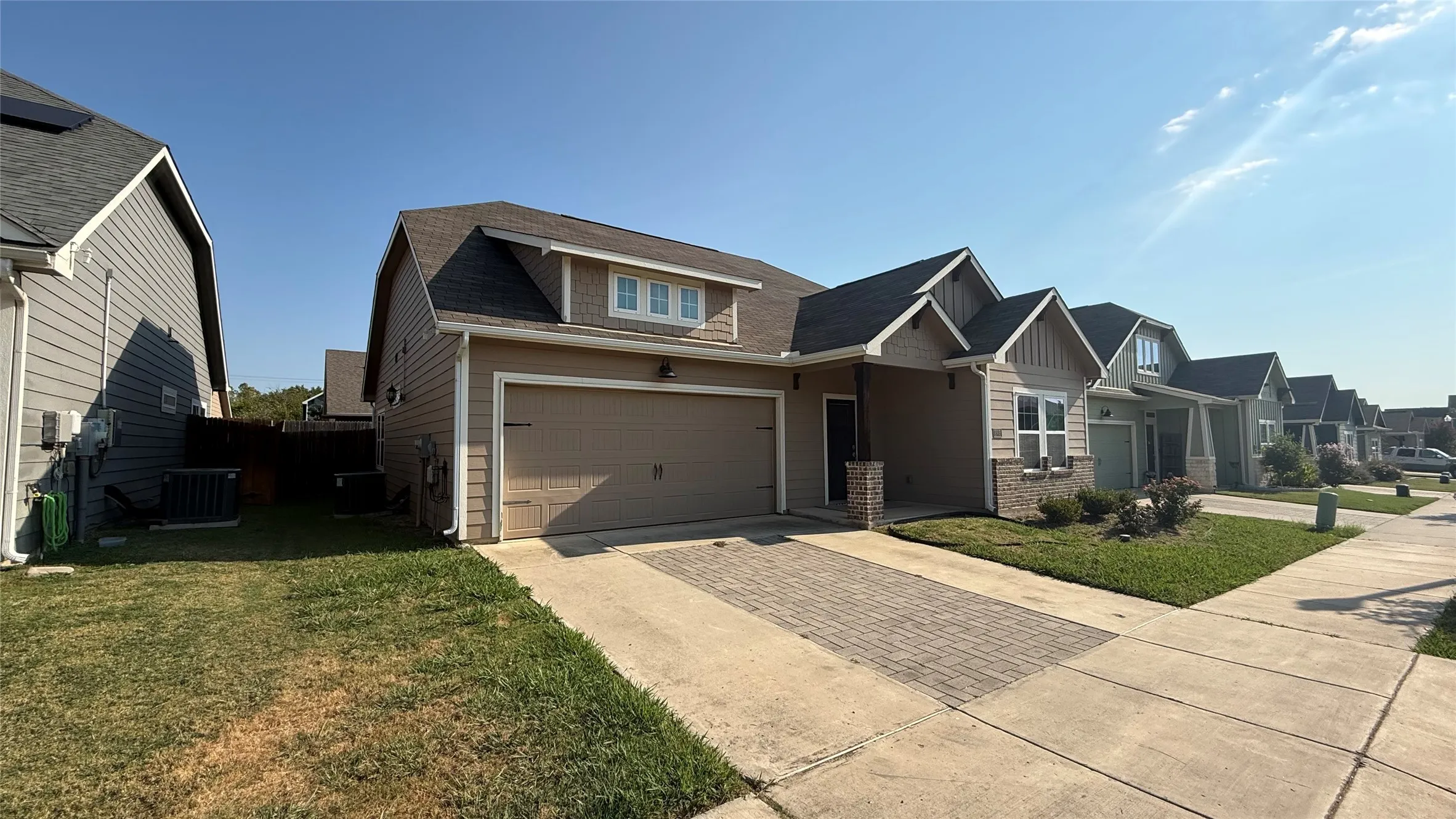 Single-story residence featuring a two-car garage, brick veneer accents, and a shingled roof