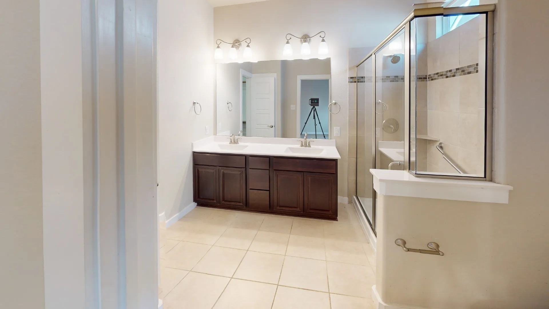 Dual vanity with dark wood-finish cabinetry, white countertops, and brushed nickel fixtures