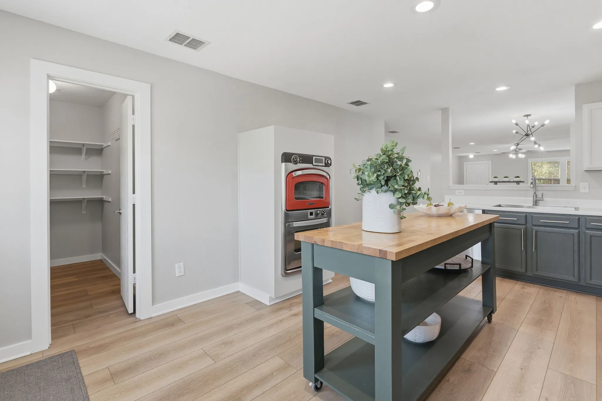 This view showcases the home’s spacious open-concept design with continuous LVP flooring and a seamless connection between dining and living areas.