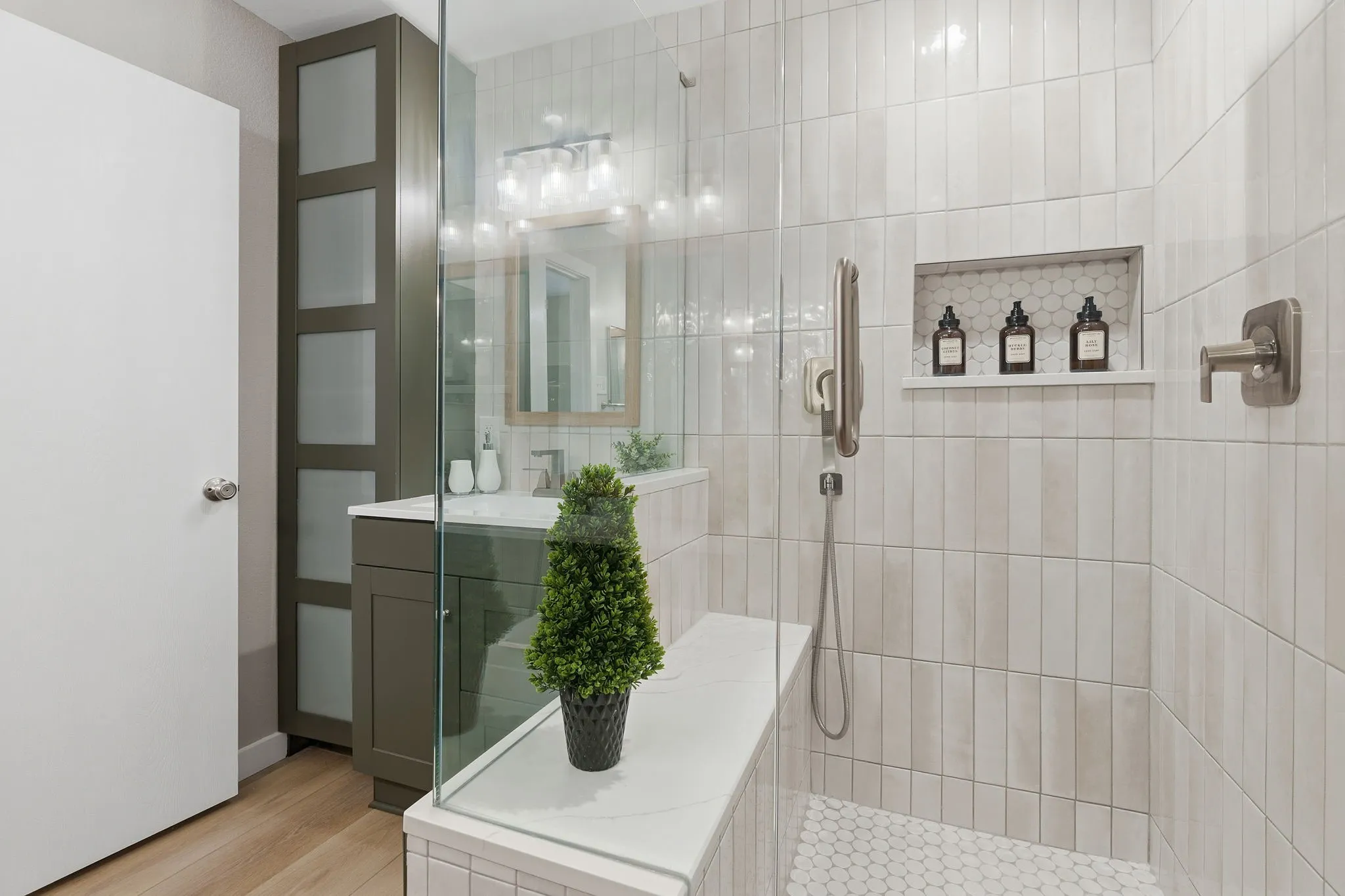 Spa-inspired shower features floor-to-ceiling tile, a built-in niche, rainfall showerhead and additional body-spray fixture.