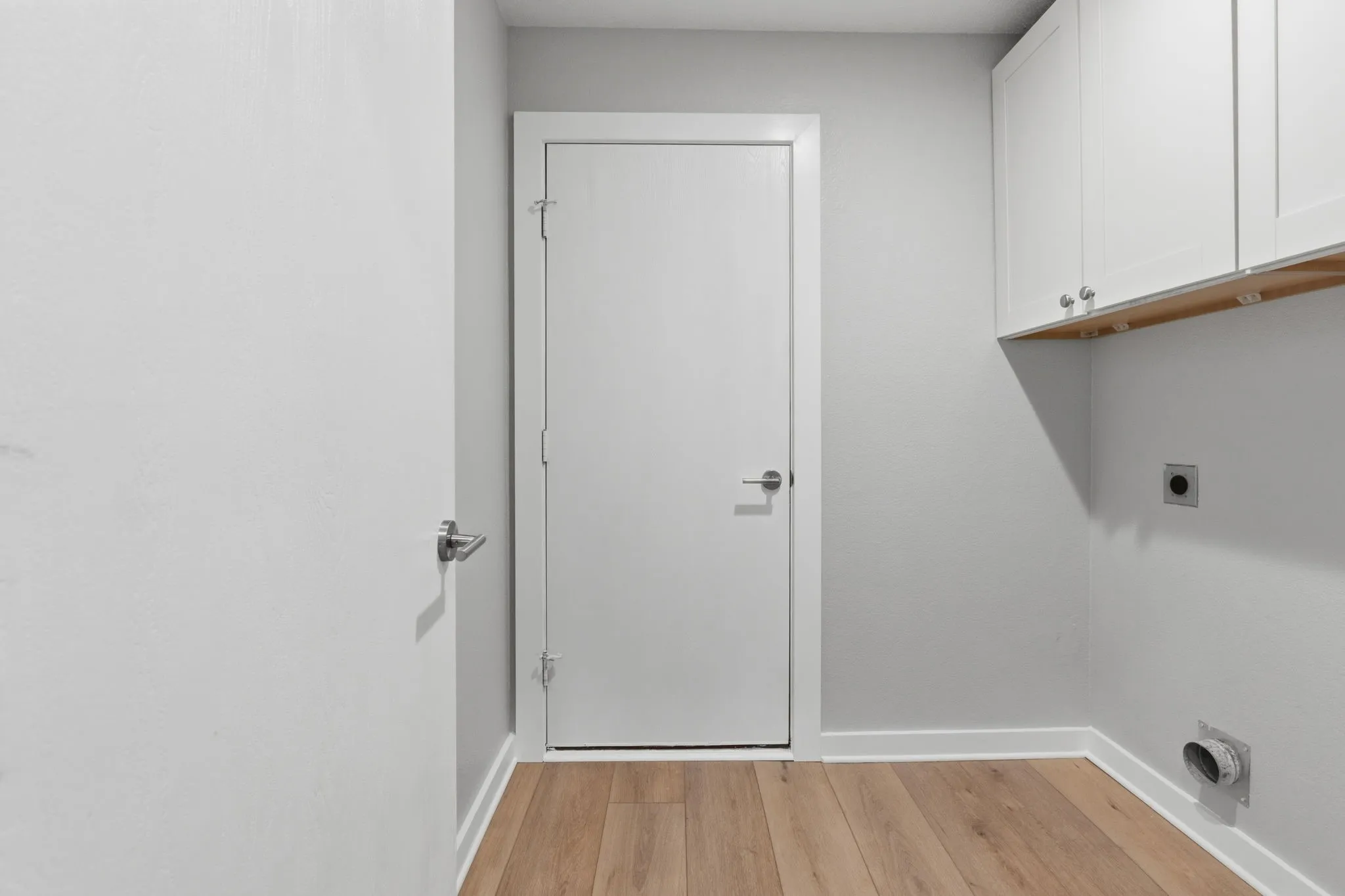 Separate utility room offers upper cabinetry, washer and dryer connections, exterior access and a convenient pull-out hanging rack tucked inside the cabinetry.