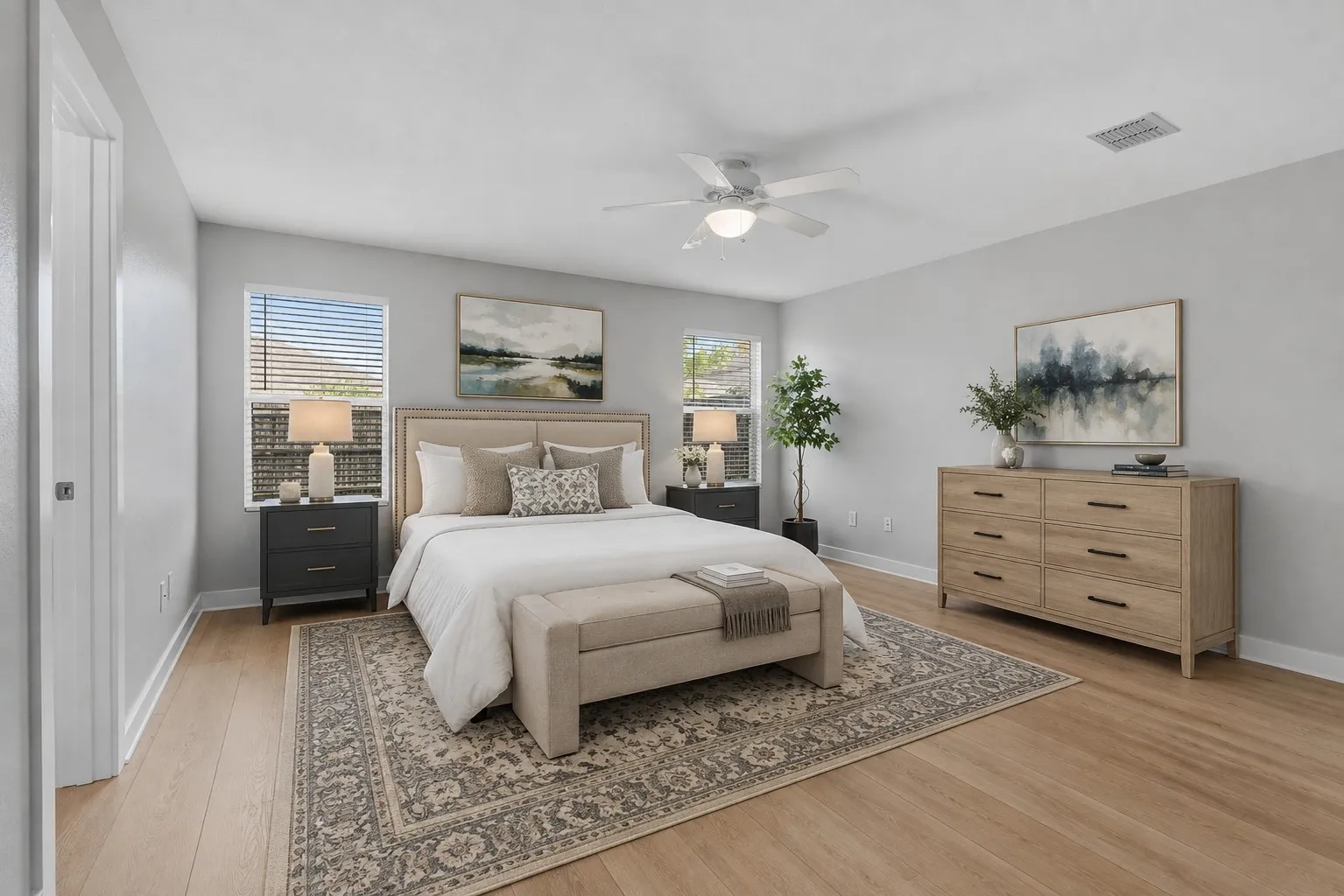 Reality staged image demonstrates how easily the spacious primary suite accommodates a king-size bed, nightstands, dresser and additional furnishings