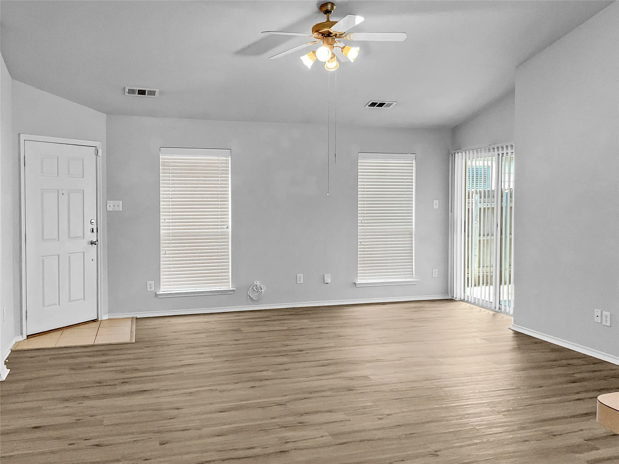 Empty room featuring light wood-type flooring, lofted ceiling, and ceiling fan