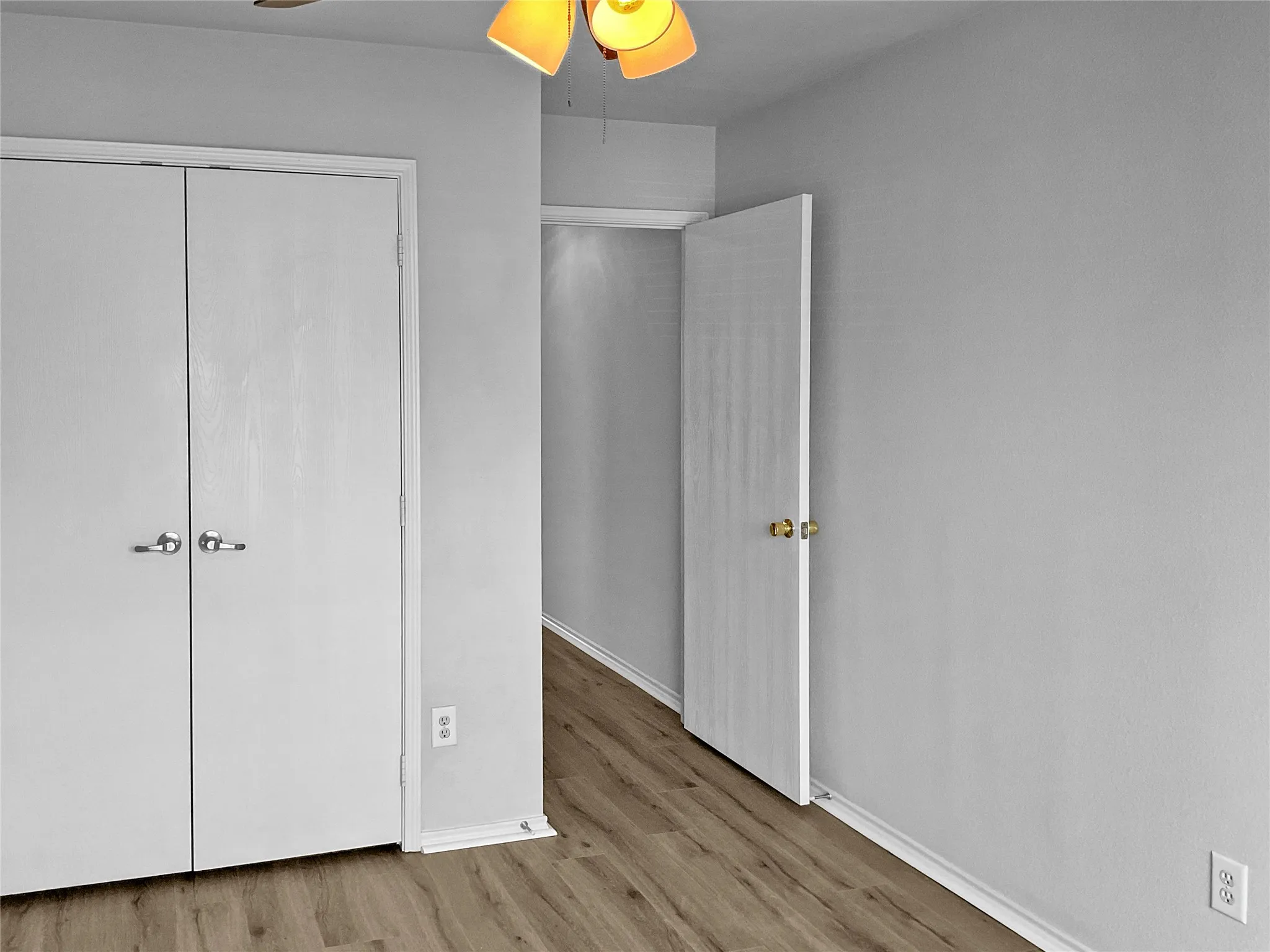 Unfurnished bedroom featuring hardwood / wood-style floors, a closet, and ceiling fan