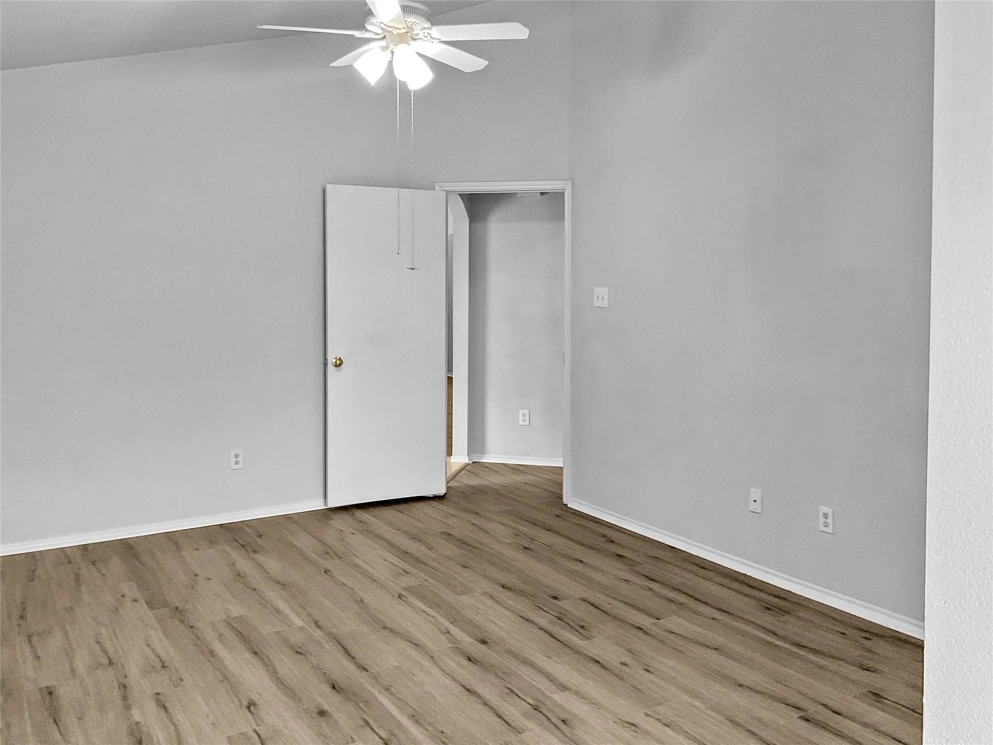 Spare room with wood-type flooring and ceiling fan
