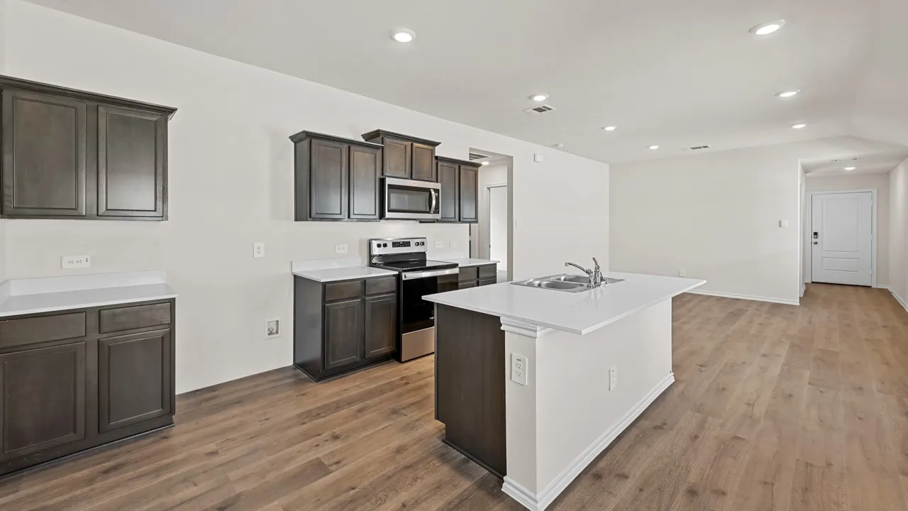 Kitchen with dark wood-finish cabinetry, white countertops, and stainless steel appliances