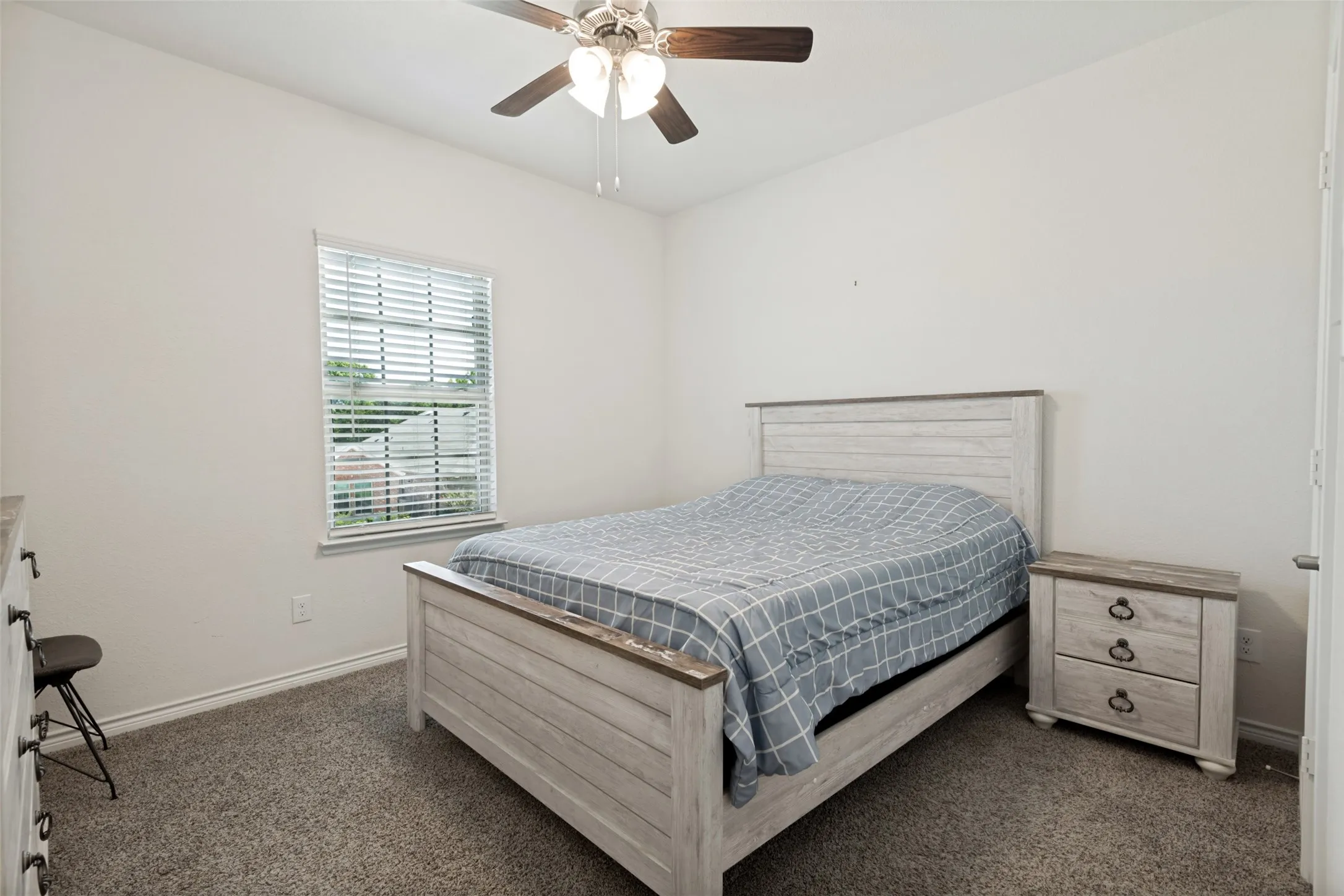 Comfortable upstairs bedroom with a ceiling fan and a spacious, versatile layout.