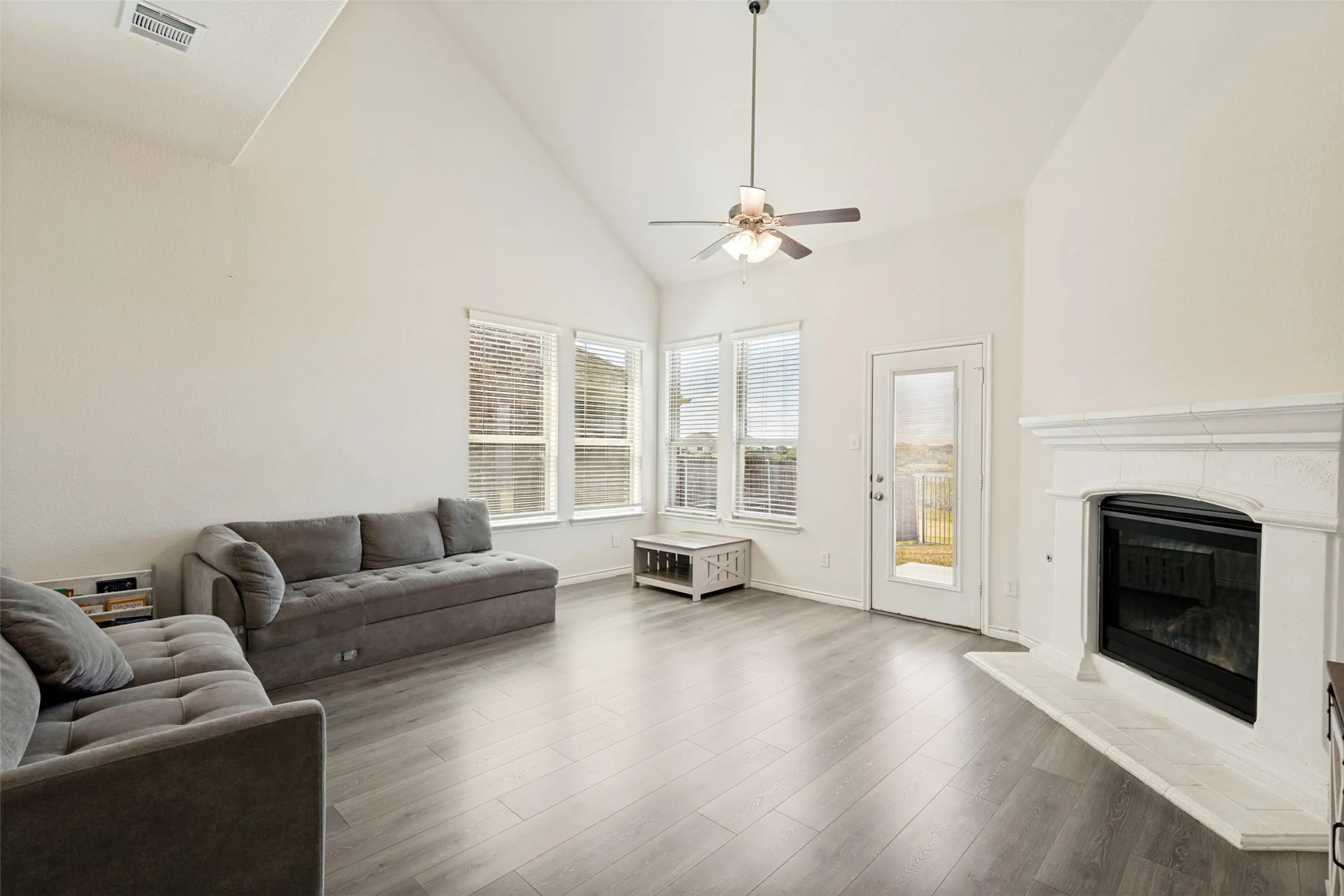 Inviting living room with a gas fireplace, overlooking the backyard.