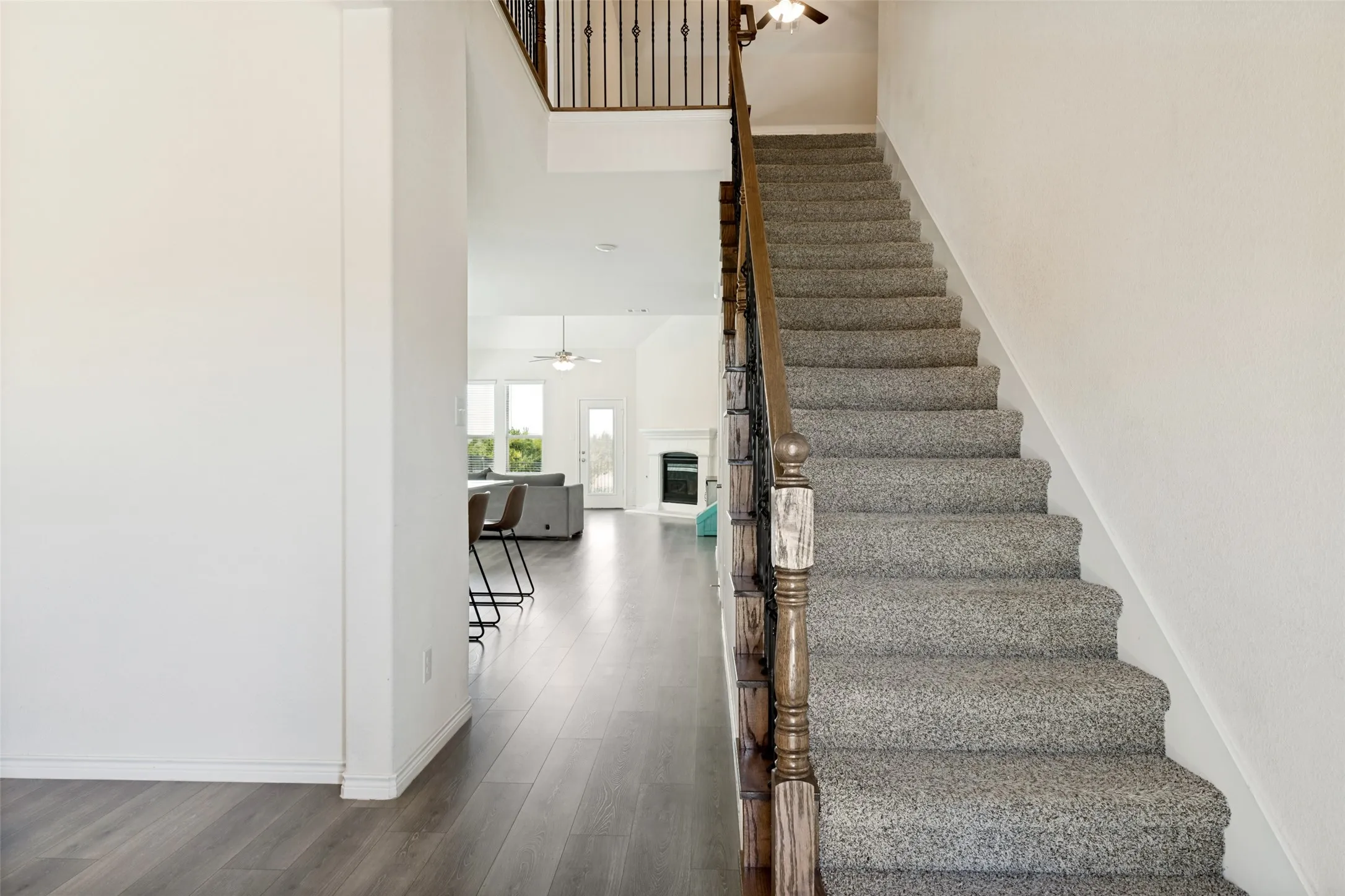 Bright, welcoming entry opens to the main living area with an open staircase leading upstairs.