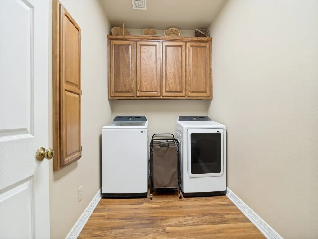 Laundry room with built-in cabinets and ironing board.  Room for a second frig or freezer.