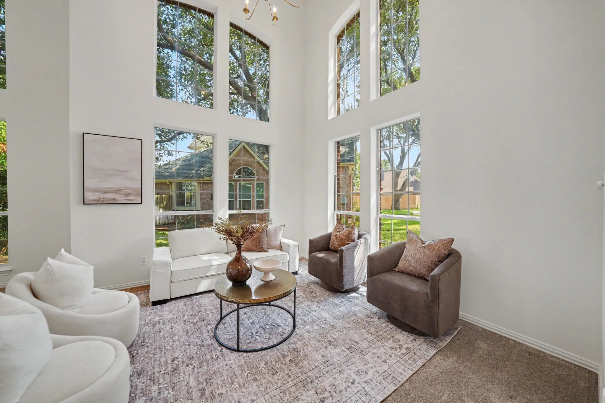 Formal Living room - Two-story ceilings with expansive windows, light-toned walls, and a new chandelier fixture