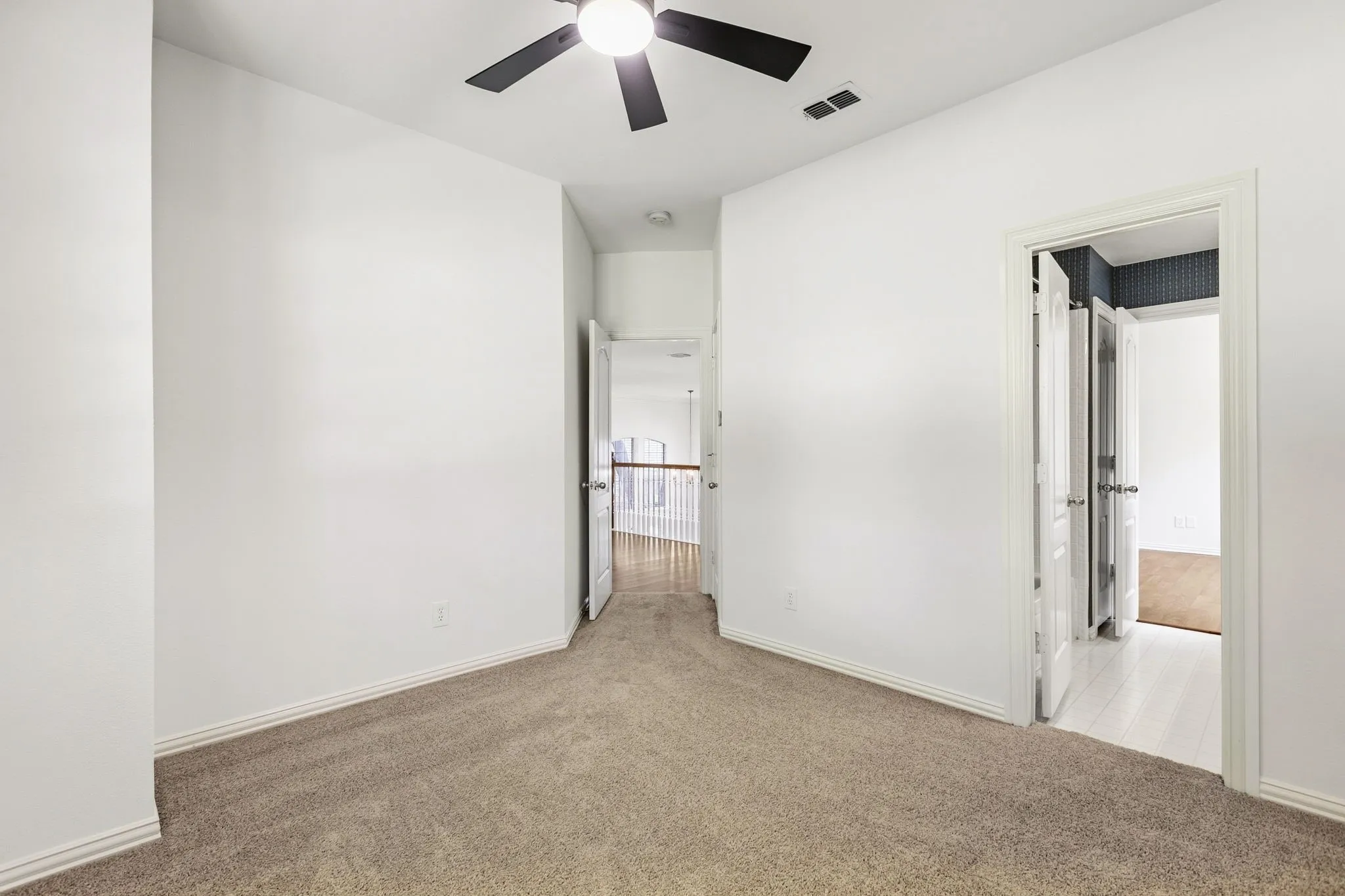 Guest Bedroom 1: on second floor shares bathroom with loft living room space. Neutral carpet flooring, white painted walls, a double window, and an overhead ceiling fan with lighting