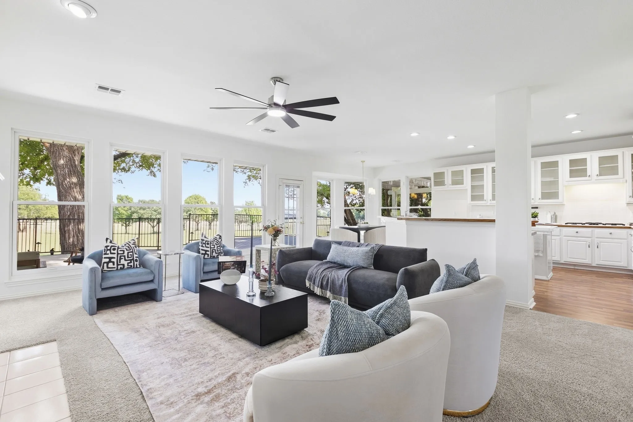 Spacious living area featuring expansive windows, recessed lighting, and a ceiling fan
