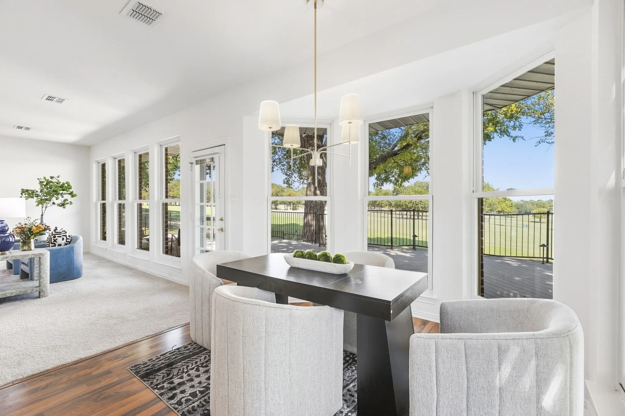 Enjoy the view from the large windows overlooking the golf course, new chandelier, and a glass-paneled exterior door.