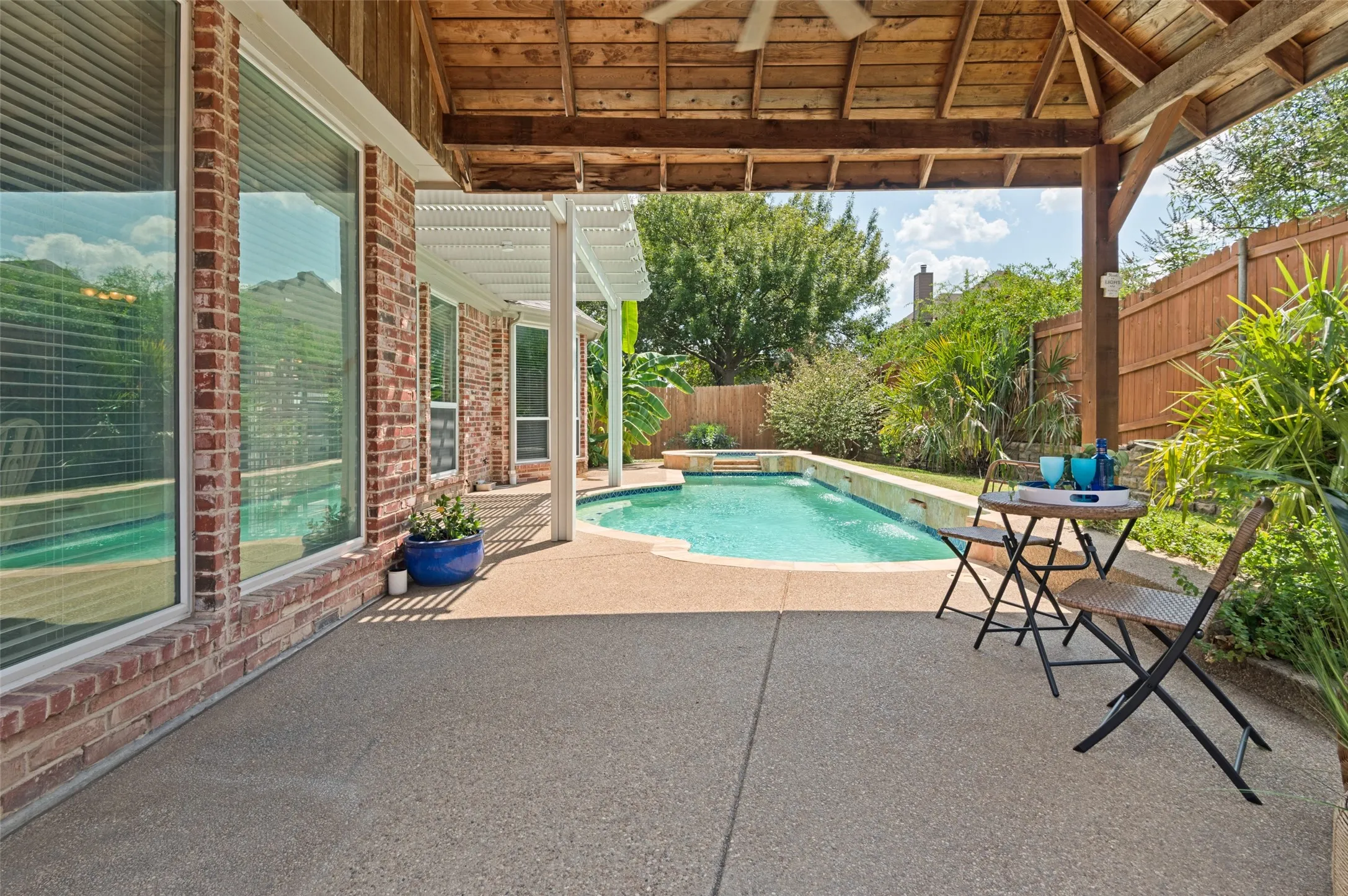 Large covered patio with recently installed fan provides a beautiful spot to enjoy outdoor living.