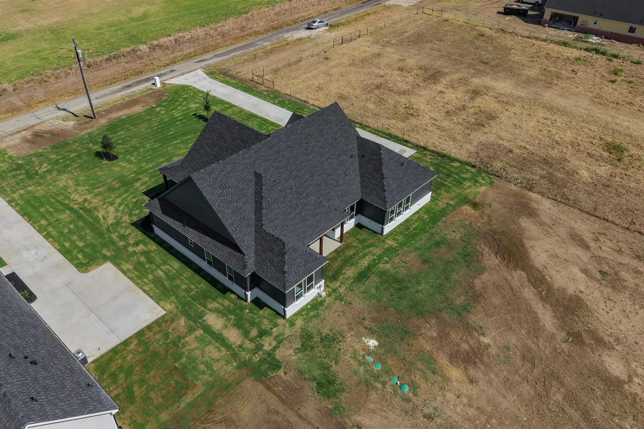 Single-story residence with a dark shingle roof, light-colored foundation, and a covered porch