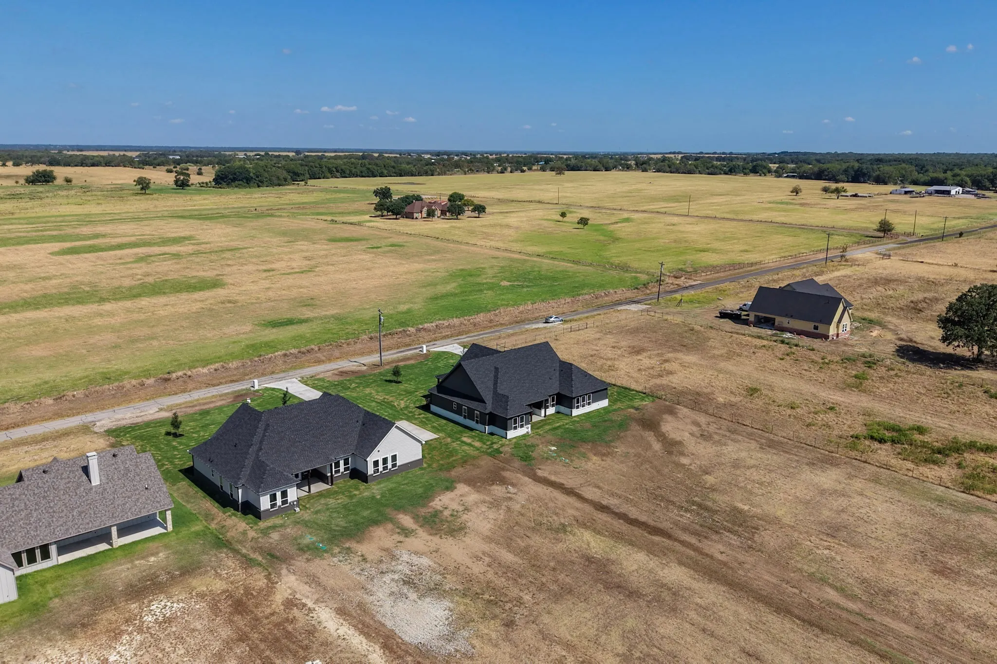 Expansive rural landscape with multiple residences and a private road