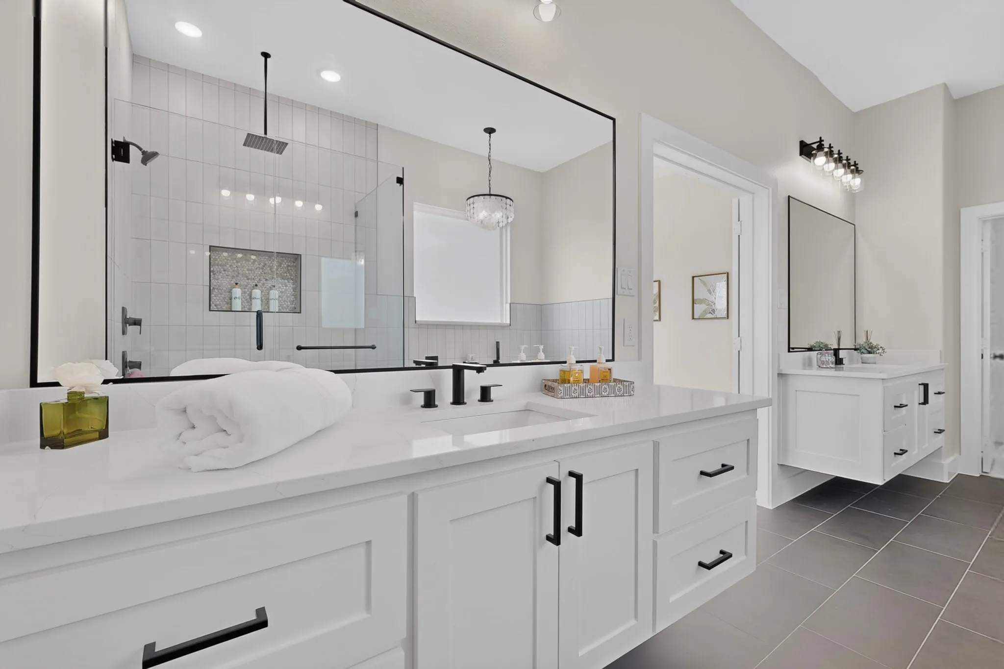 Dual white vanities with integrated sinks and black hardware