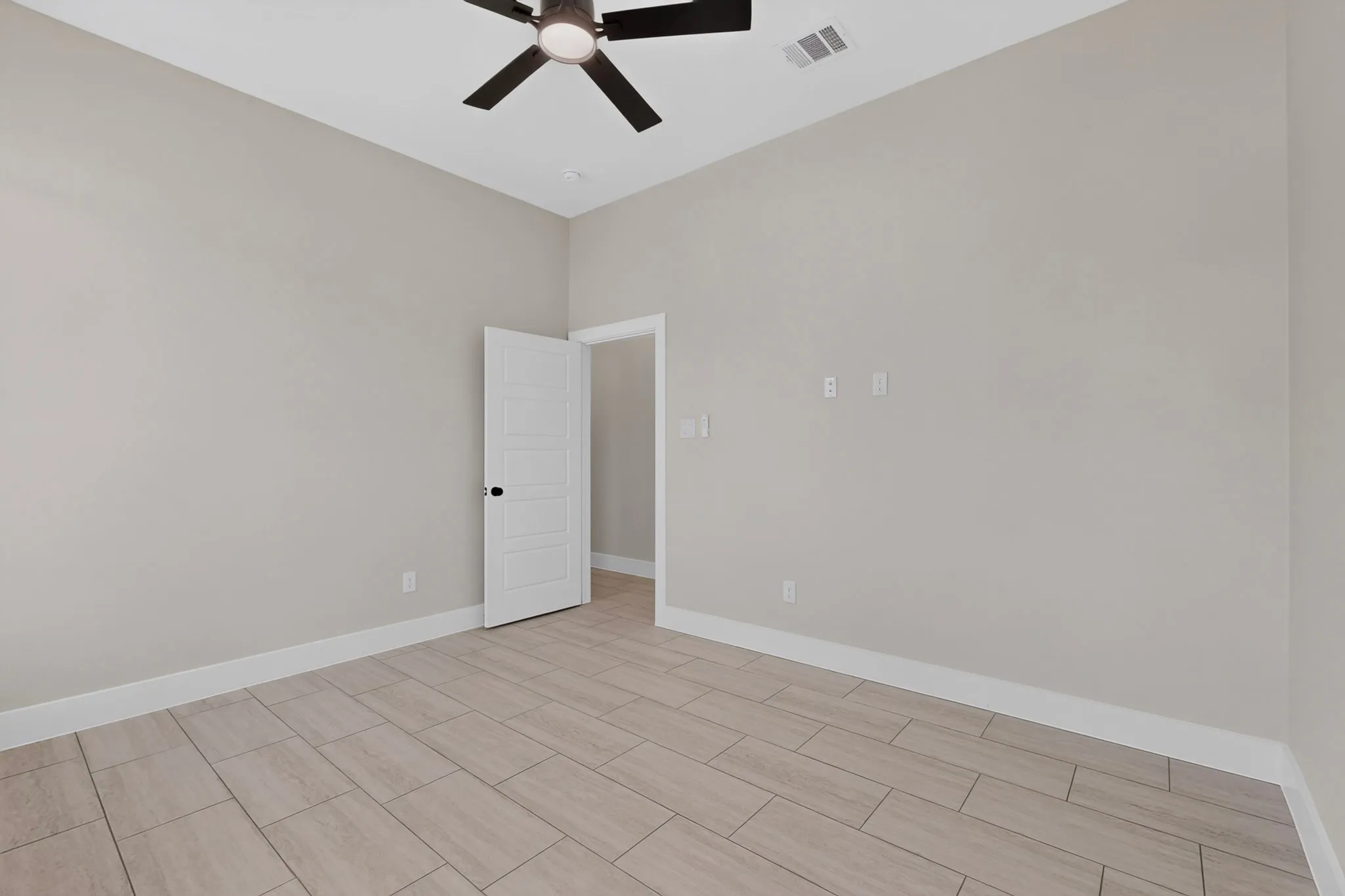 Light-toned tile flooring, neutral wall paint, white trim, and a ceiling fan with integrated lighting