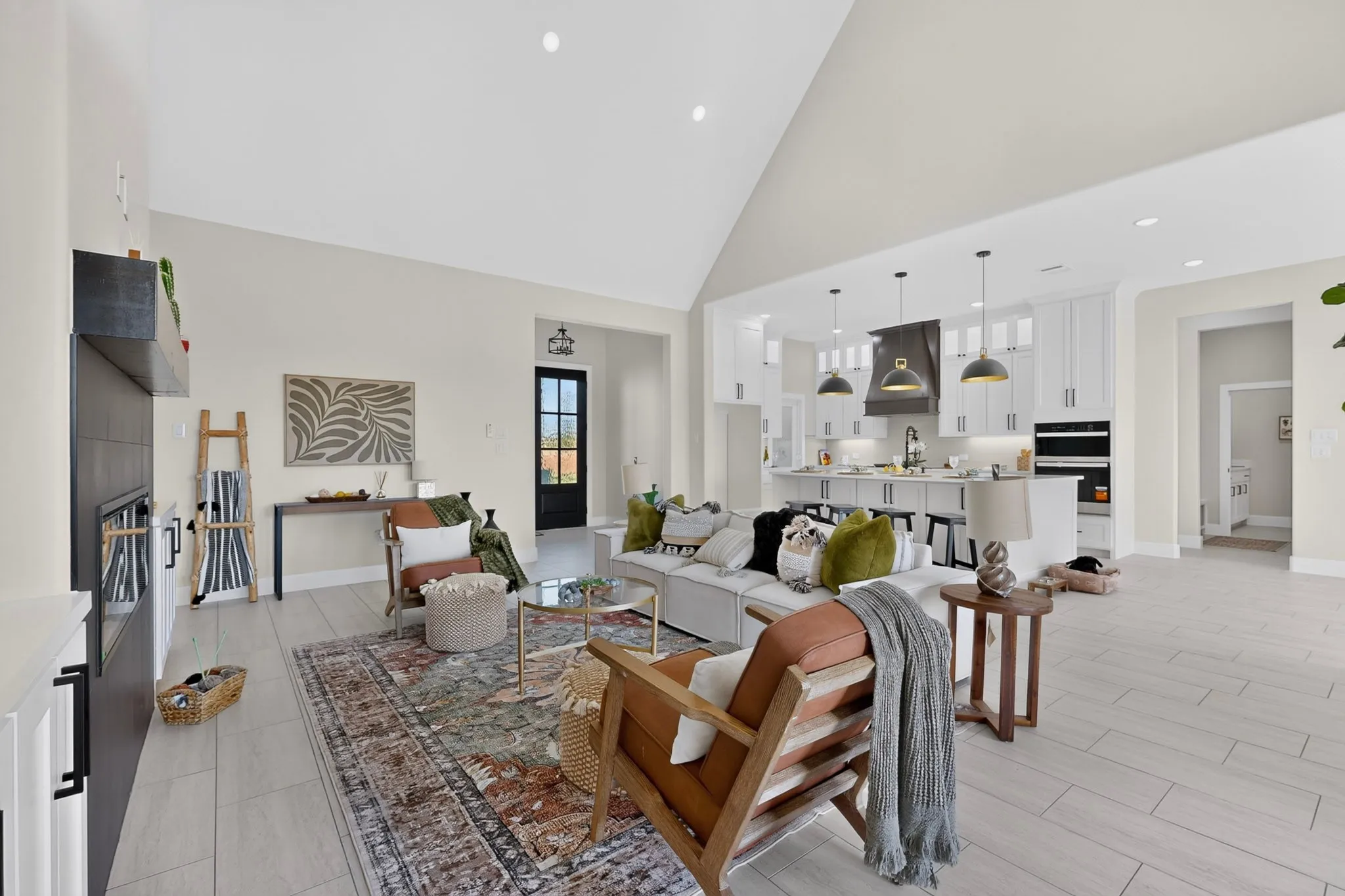 Vaulted ceiling, recessed lighting, wood-finish flooring, built-in fireplace, and a kitchen island with pendant lighting