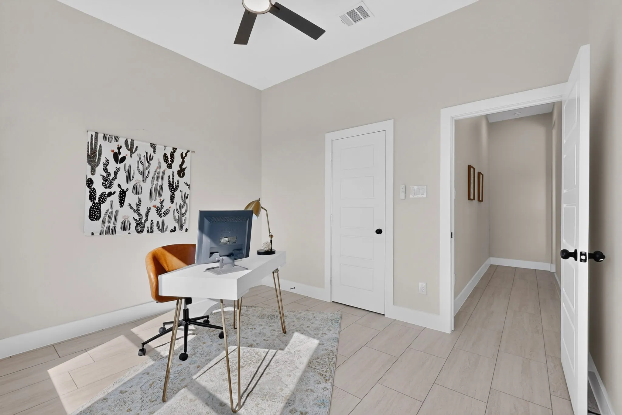 Vaulted ceiling with a ceiling fan, light wood-finish flooring, white paneled doors with black hardware, and light-colored wall paint