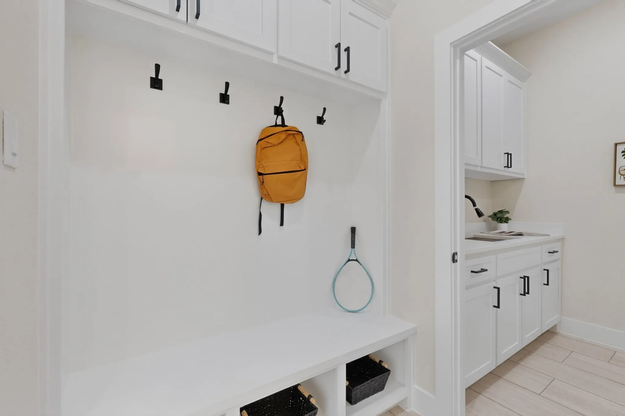Built-in mudroom bench with upper cabinetry and storage cubbies
