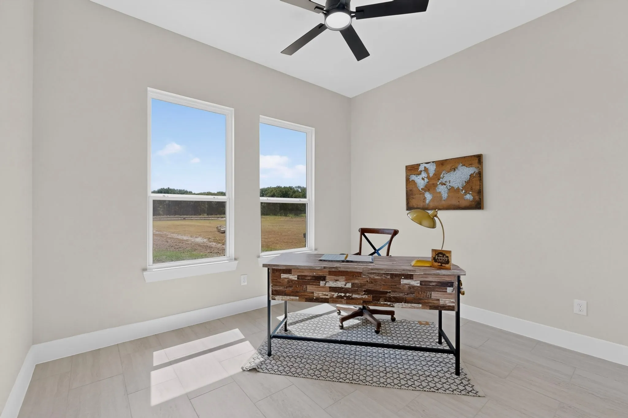 Two large windows, ceiling fan, neutral wall paint, and light-toned tile flooring