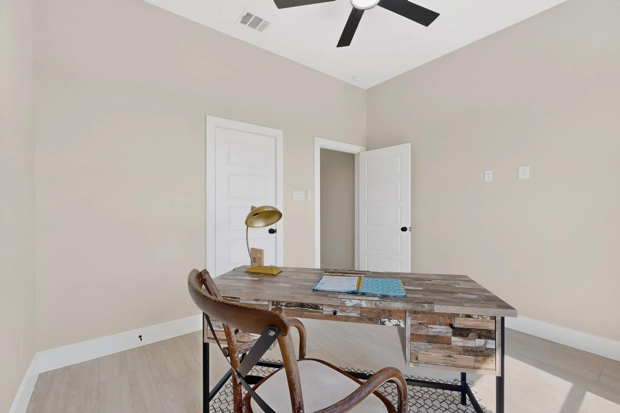 Vaulted ceiling with a ceiling fan, light wood-finish flooring, and two paneled interior doors