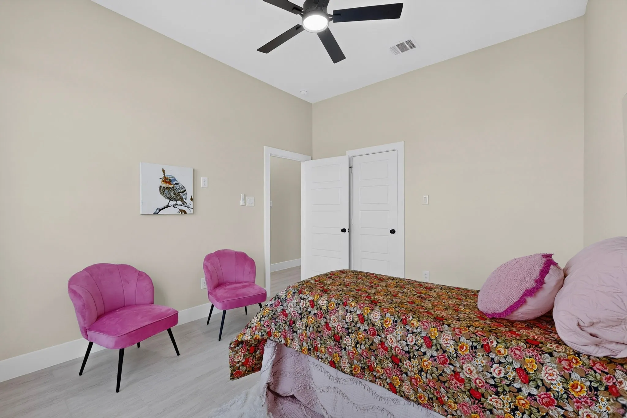 Neutral wall paint, light wood-finish flooring, and a ceiling fan with integrated lighting