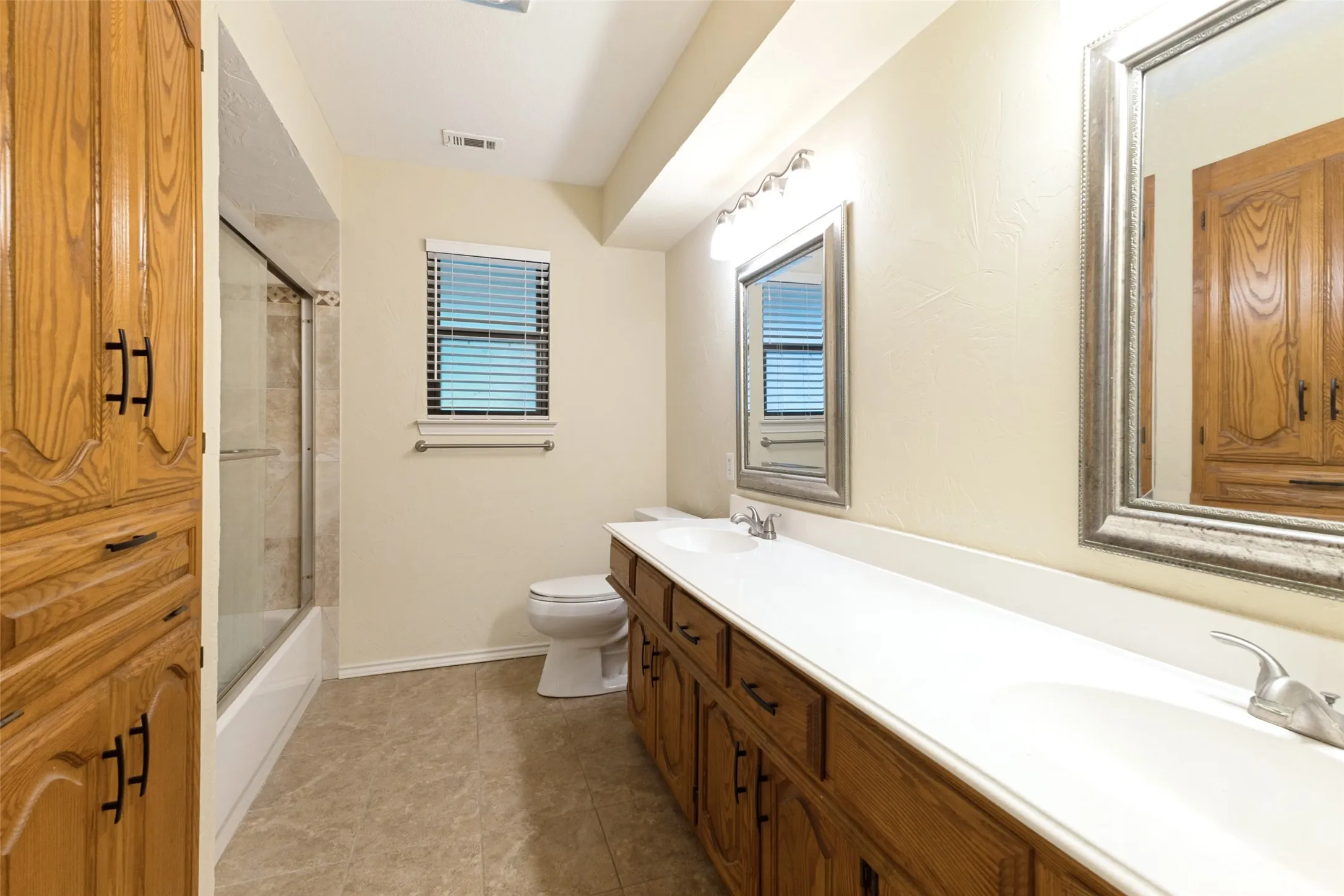 Secondary bathroom with dual sinks and a ton of storage.