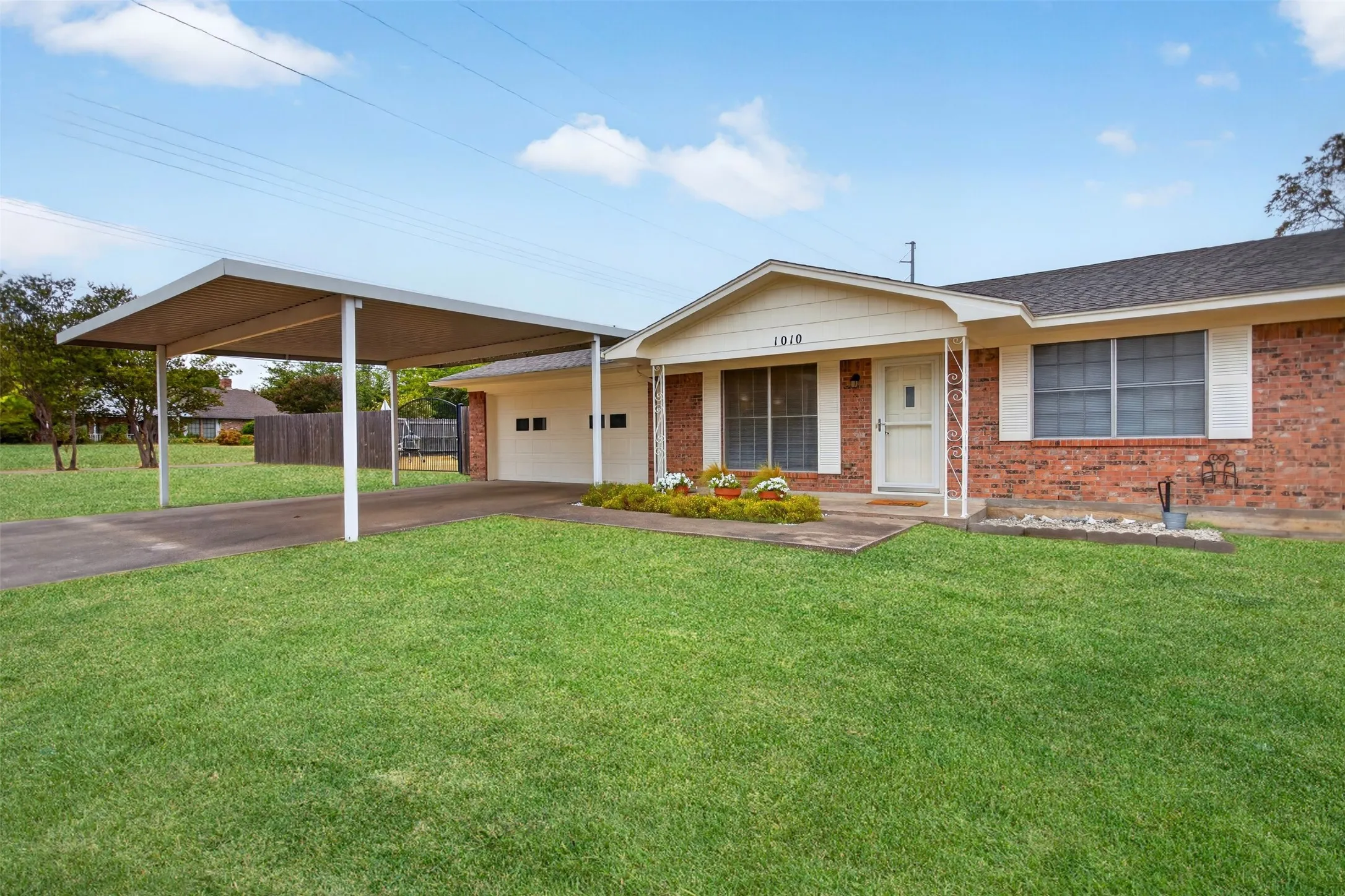 Brick exterior with a detached carport and an attached two-car garage