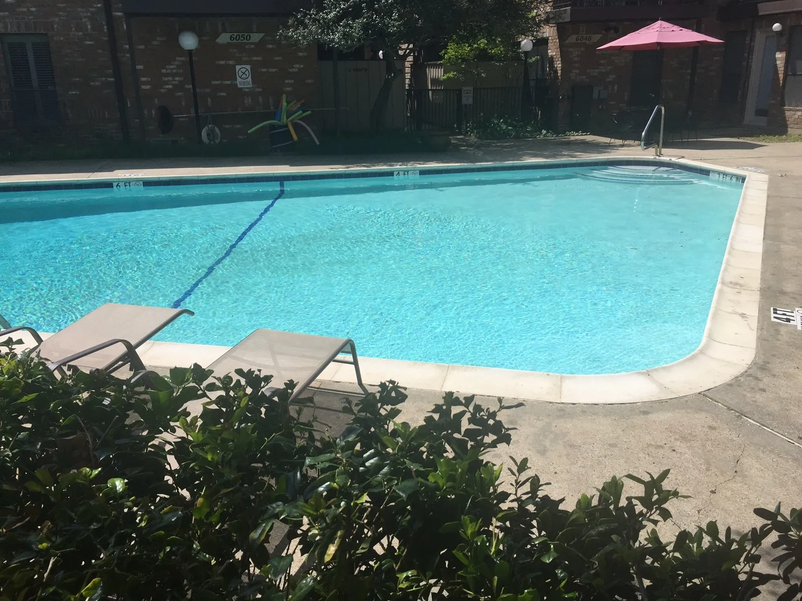 Swimming pool with concrete surround and integrated steps