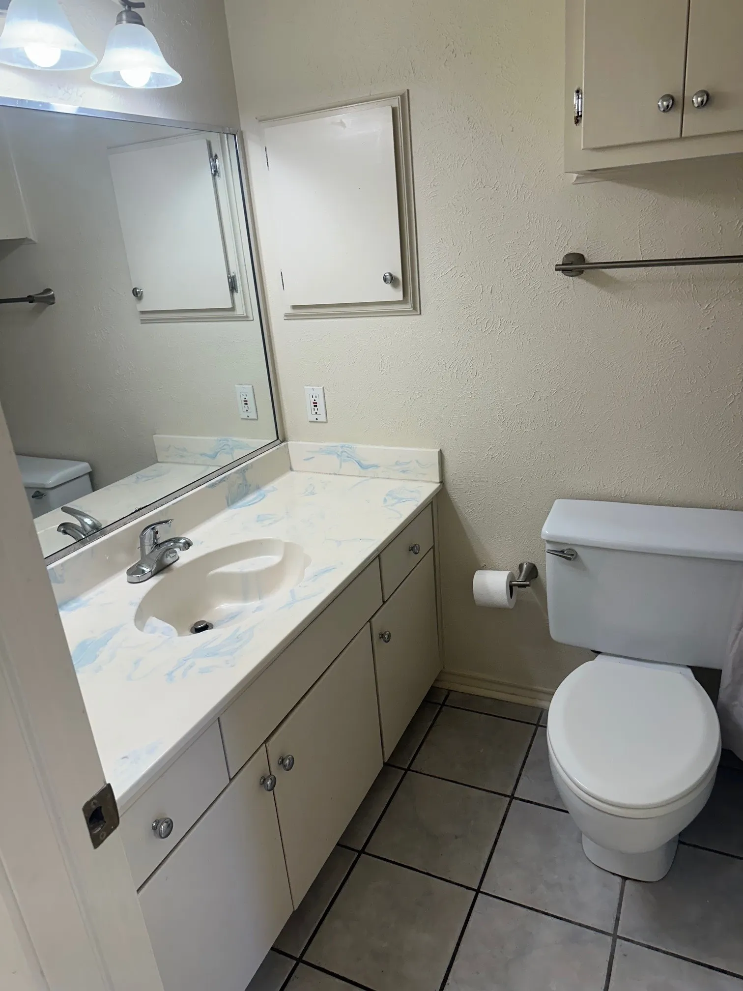White vanity with integrated sink, patterned countertop, and chrome faucet