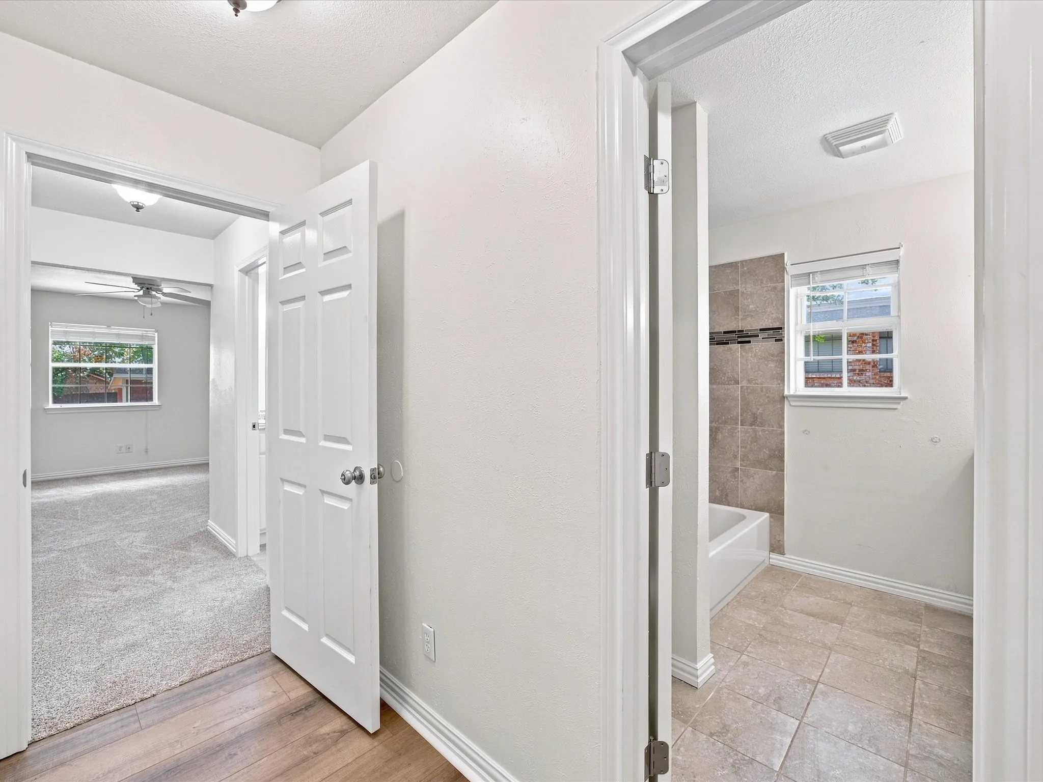 Hallway with view to primary bedroom and guest bathroom