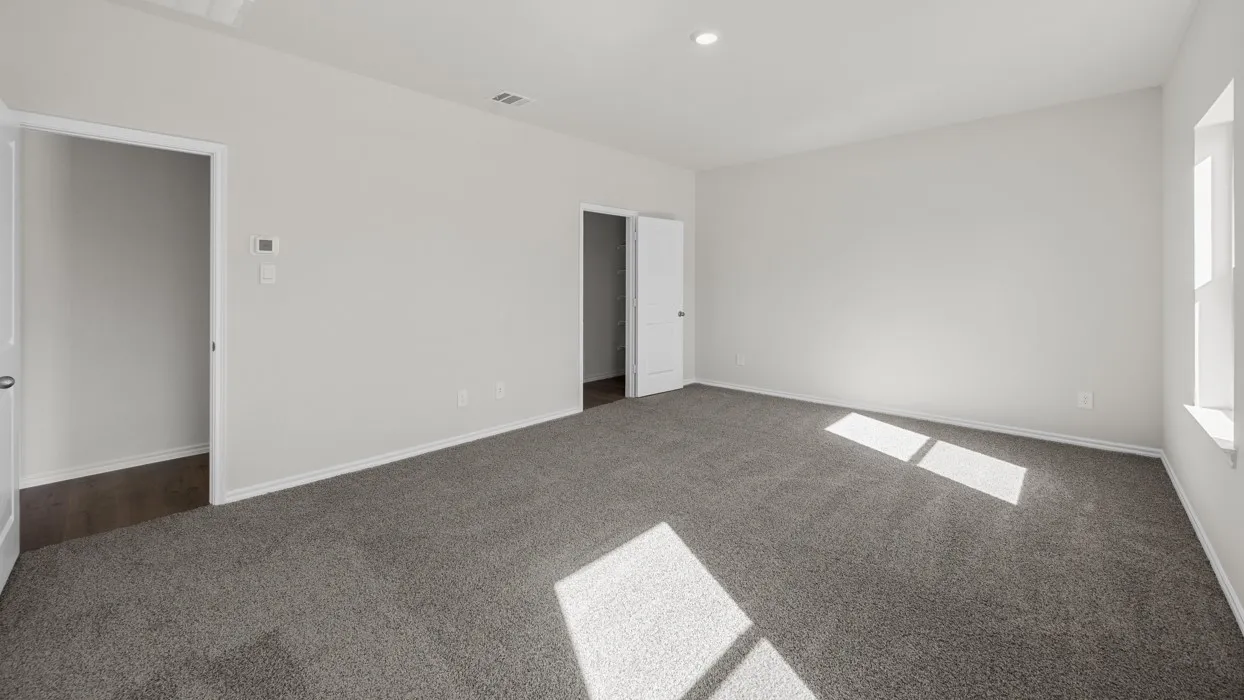 Spacious room featuring neutral carpet flooring, light-toned walls, and recessed lighting