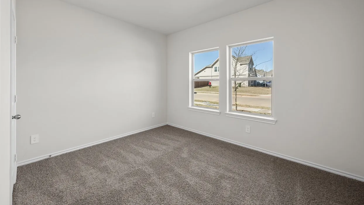Neutral wall paint, two windows, and gray carpet flooring