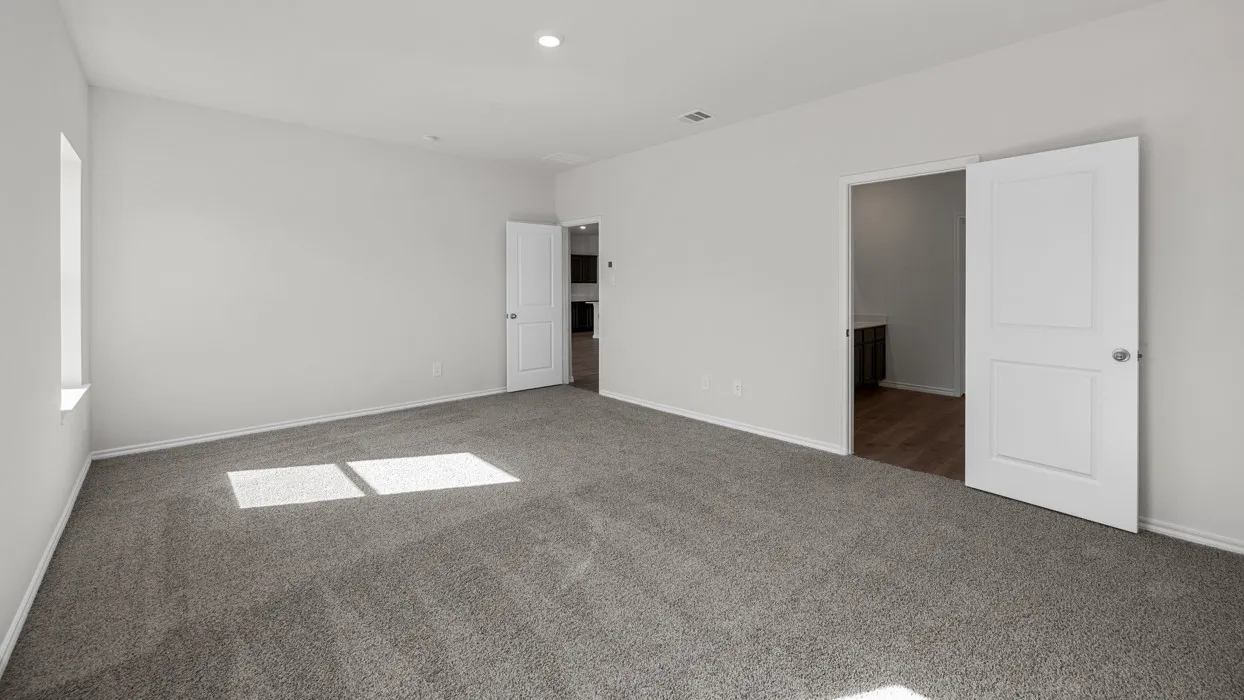 Expansive room featuring light gray carpeting, neutral wall finishes, a window, and two paneled doors with chrome hardware